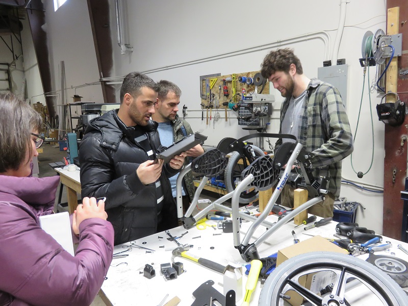 Ilir and Blerim watch as the ROC technician assembles the chair